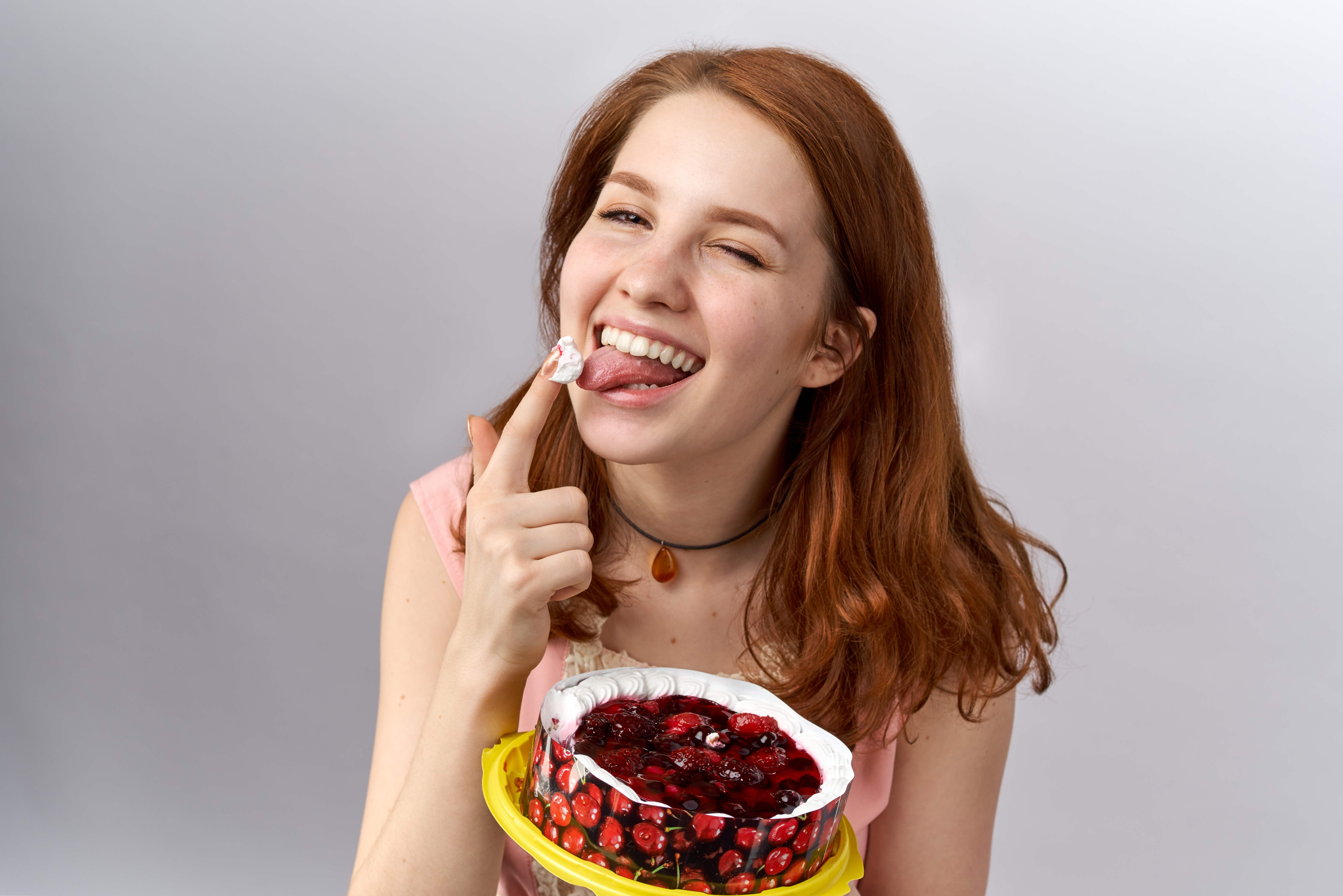 Смеющаяся женщина ест сладости